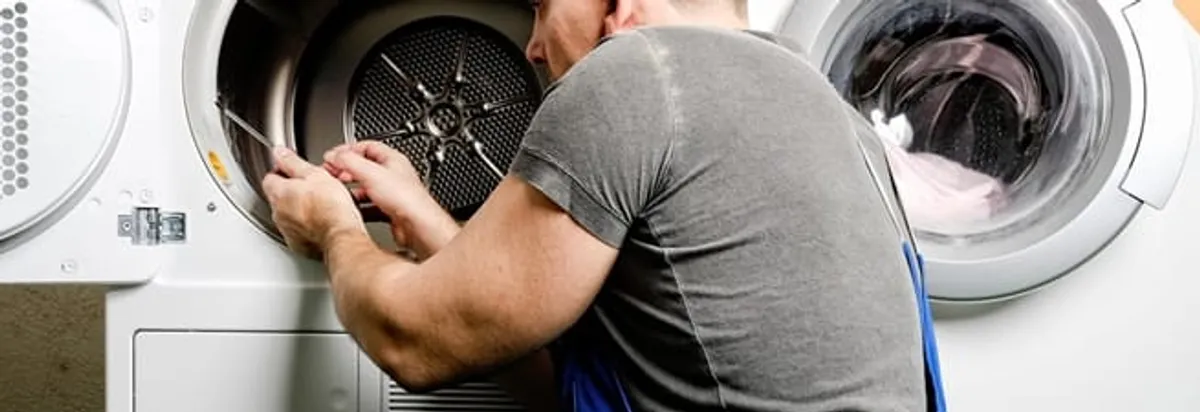 Dryer repair technician fixing a clothes dryer drum in Dallas, TX