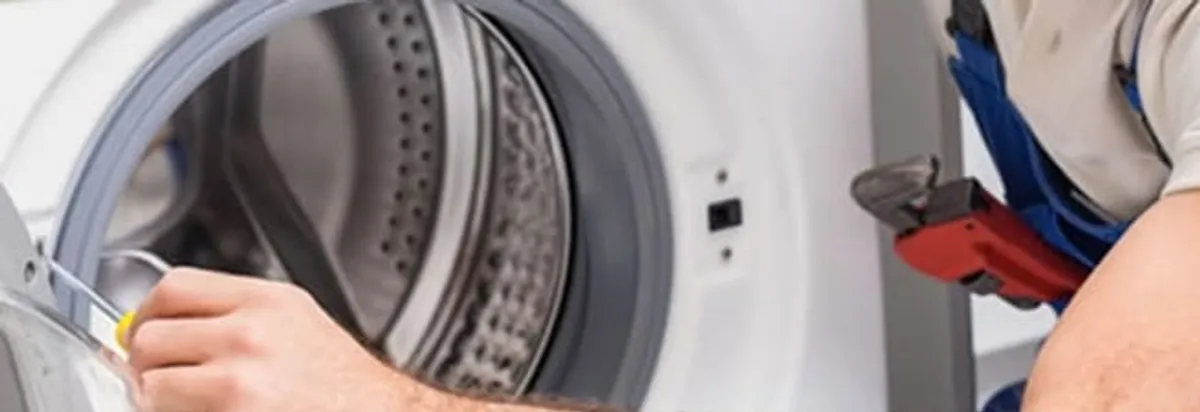 Appliance technician repairing a clothes dryer drum and internal parts in Dallas, TX