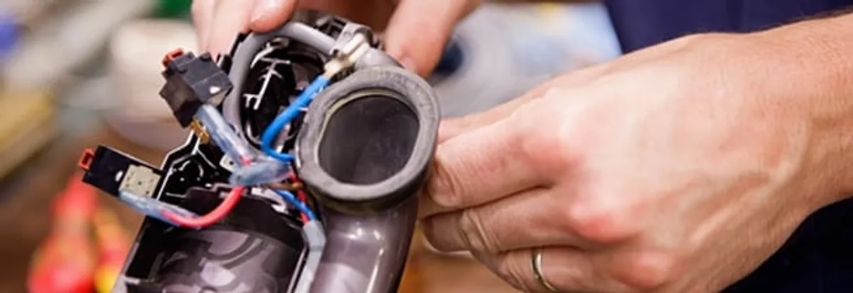 Vacuum repair technician reconnecting wiring and components in Dallas, TX