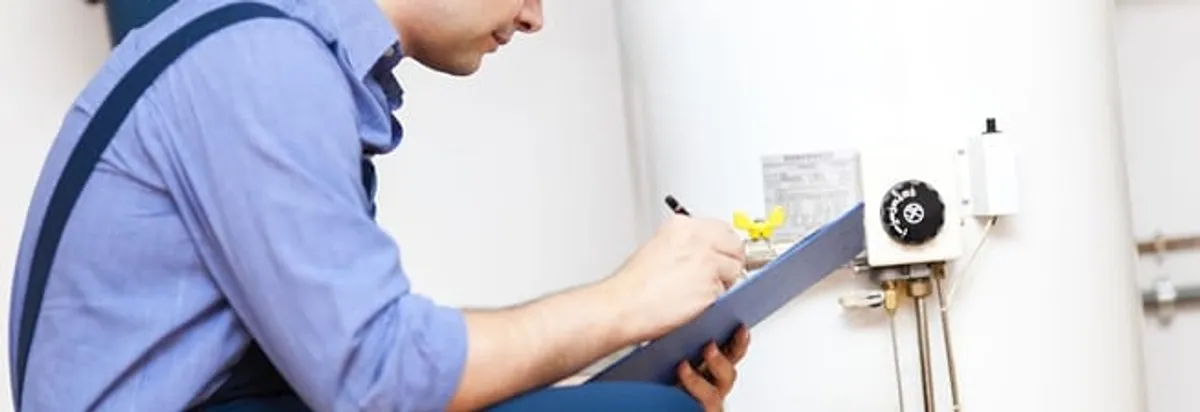 Water heater repair technician inspecting the unit and recording service notes in Dallas, TX