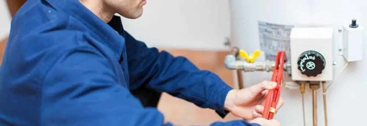 Water heater repair technician adjusting the temperature control and gas valve in Dallas, TX